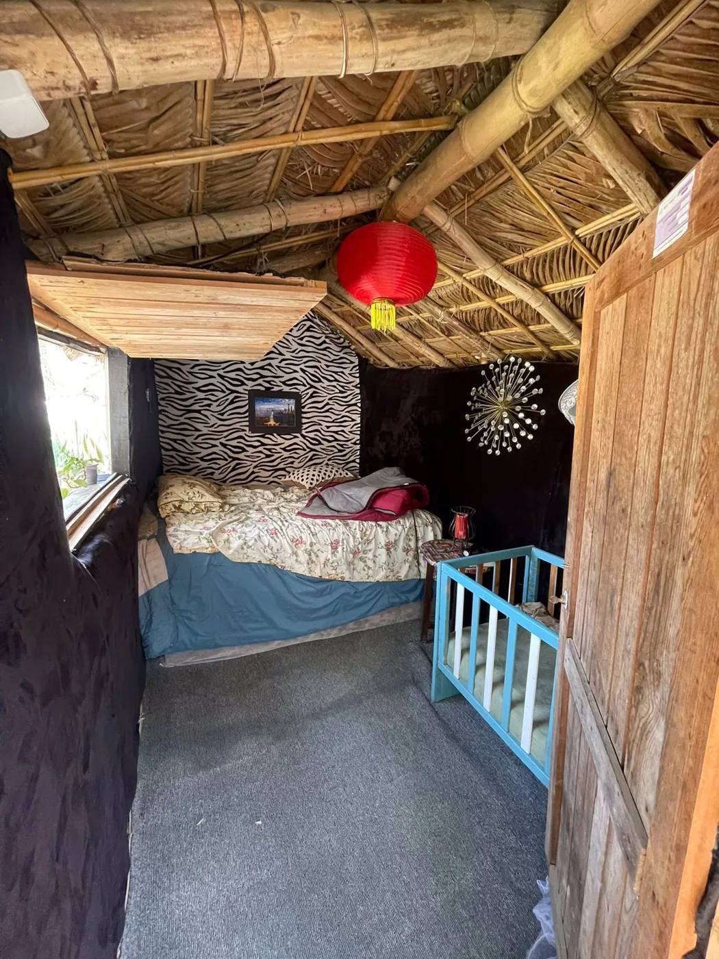 Rustic bedroom with a palm thatch ceiling and wooden walls