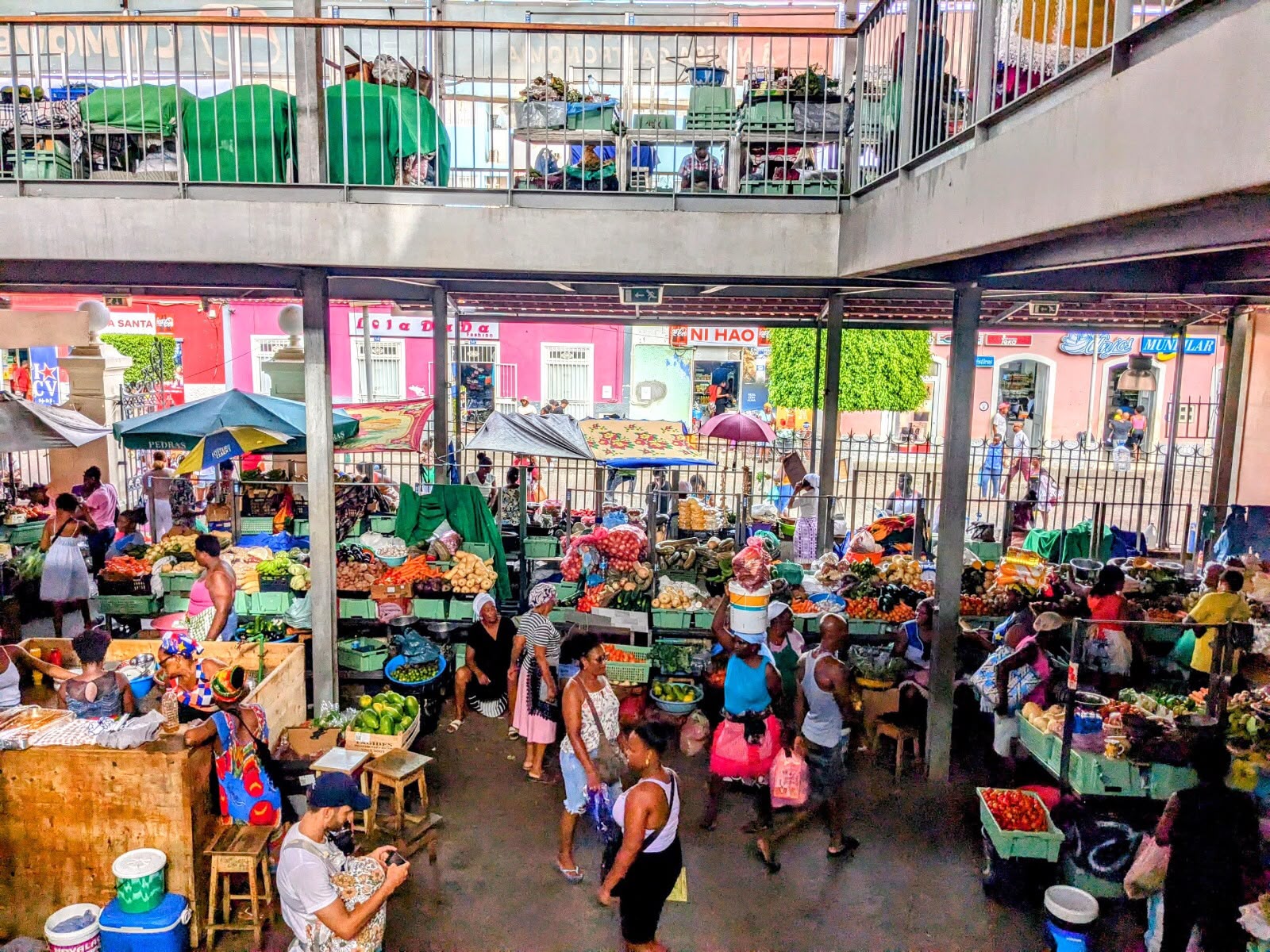 Vendors and colorful produce inside a busy market hall in Praia, Santiago
